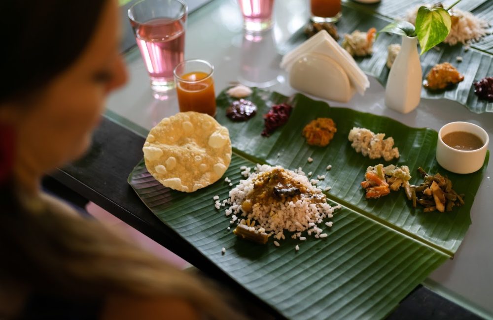 Traditional Ayurvedic meal served on banana leaf with rice, curry, vegetables, and herbal beverages arranged according to ancient nutritional principles.