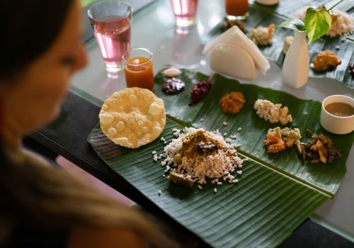 Traditional Ayurvedic meal served on banana leaf with rice, curry, vegetables, and herbal beverages arranged according to ancient nutritional principles.