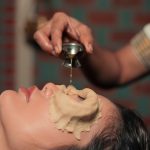Close-up of Netra Tarpana therapy with medicated ghee being poured into a dough dam around the eyes during Ayurvedic treatment