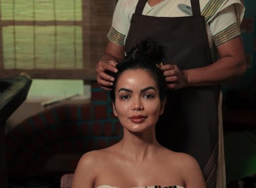 Ayurvedic therapist applying herbal oil during traditional scalp massage at Kairali Ayurvedic Health Village in Palakkad, Kerala
