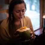 Woman enjoying fresh coconut water at an Ayurvedic retreat in Kerala