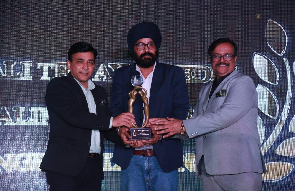 Three men holding an award trophy at the Global Tourism Awards 2025, representing Kairali Ayurvedic Healing Village's win as Best Wellness Resort.