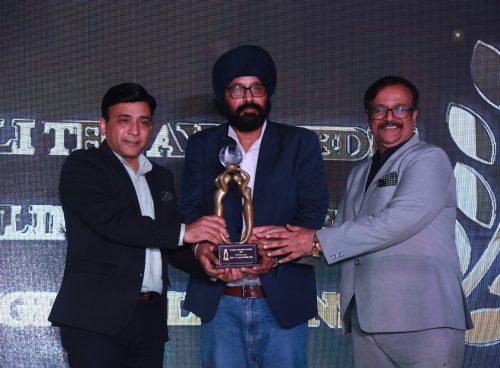 Three men holding an award trophy at the Global Tourism Awards 2025, representing Kairali Ayurvedic Healing Village's win as Best Wellness Resort.