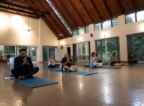 Group meditation in airy yoga hall at Kairali Ayurvedic Healing Village, Kerala.