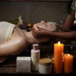 Ayurvedic facial massage at Kairali – therapist massaging a guest’s face beside warm candlelight in a traditional Kerala treatment room
