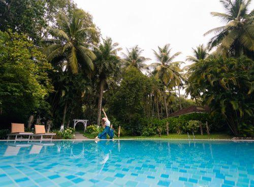 Yoga by the pool at Kairali – The Ayurvedic Healing Village in Kerala, surrounded by palms and tropical gardens