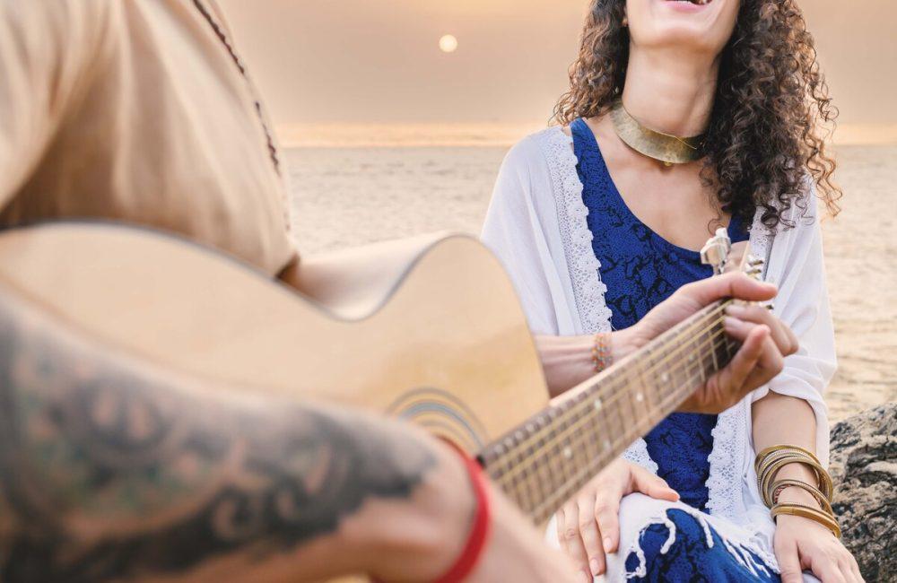 Couple at sunset on Agonda Beach, Goa—live guitar, laughter, and privacy at an exclusive beach villa in India.