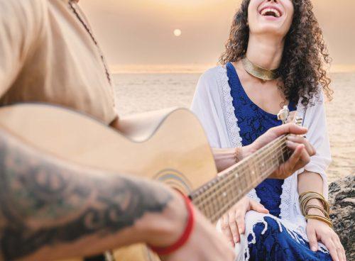 Couple at sunset on Agonda Beach, Goa—live guitar, laughter, and privacy at an exclusive beach villa in India.