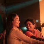 Smiling solo female guest lights traditional oil lamps with a caring staff member at Kairali Ayurvedic Palakkad—an emotionally safe, non-judgmental Ayurveda retreat in Kerala.