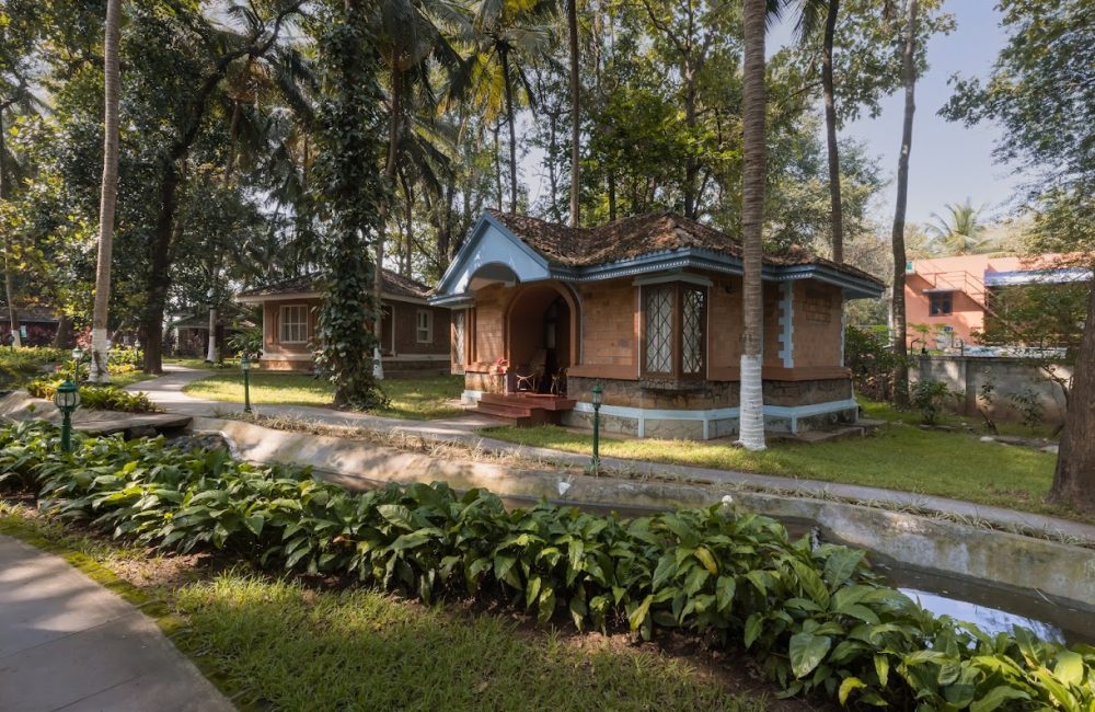 Traditional Kerala cottage surrounded by palm trees at Kairali Ayurvedic Health Retreat Kerala, designed for peaceful solo female Ayurveda stays