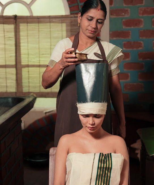 Ayurvedic therapist performing Shirovasti (warm oil therapy) at Kairali – The Ayurvedic Healing Village, Kerala