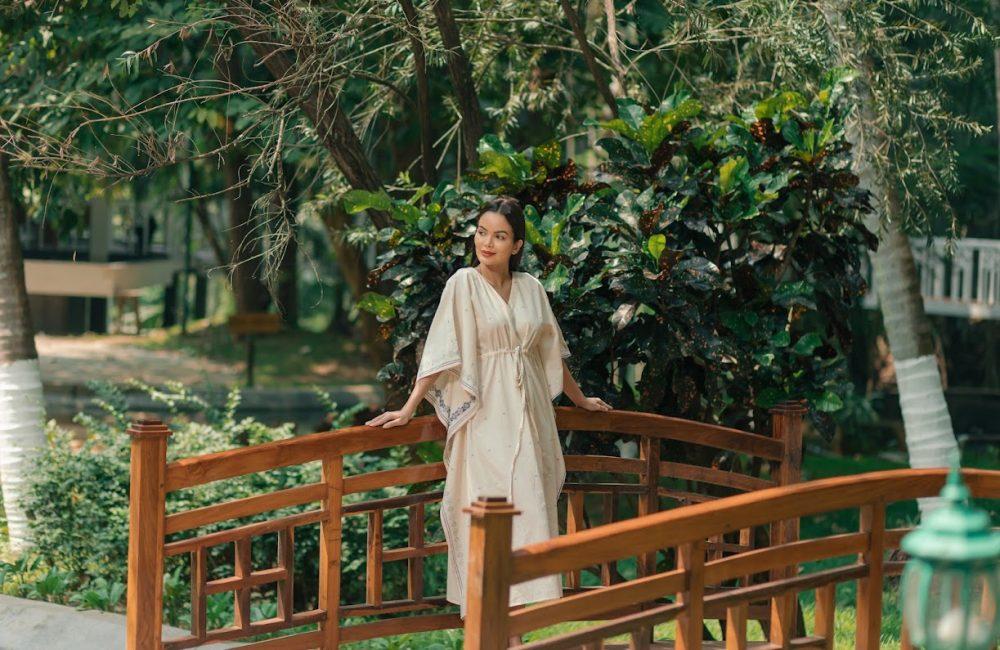 Woman enjoying a quiet moment in nature after an Ayurvedic retreat, reflecting calm and balance before returning home