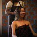 Ayurvedic therapist gently massages a woman’s scalp as she sits relaxed with eyes closed in a serene treatment room.