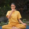 Woman practicing seated pranayama breathing exercise outdoors, an easy office-friendly yoga practice for people who sit all day