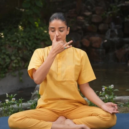 Woman practicing seated pranayama breathing exercise outdoors, an easy office-friendly yoga practice for people who sit all day