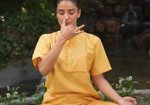 Woman practicing seated pranayama breathing exercise outdoors, an easy office-friendly yoga practice for people who sit all day