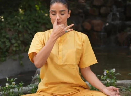 Woman practicing seated pranayama breathing exercise outdoors, an easy office-friendly yoga practice for people who sit all day