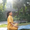 Woman practising meditation outdoors, illustrating yoga and Ayurveda for stress support.