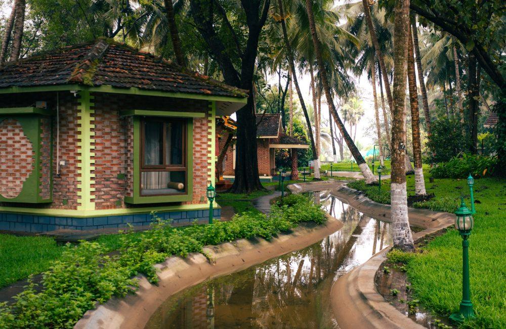 Purpose-built Ayurveda village cottages surrounded by lush greenery at a Palakkad Ayurveda retreat in Kerala