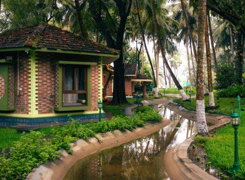 Purpose-built Ayurveda village cottages surrounded by lush greenery at a Palakkad Ayurveda retreat in Kerala