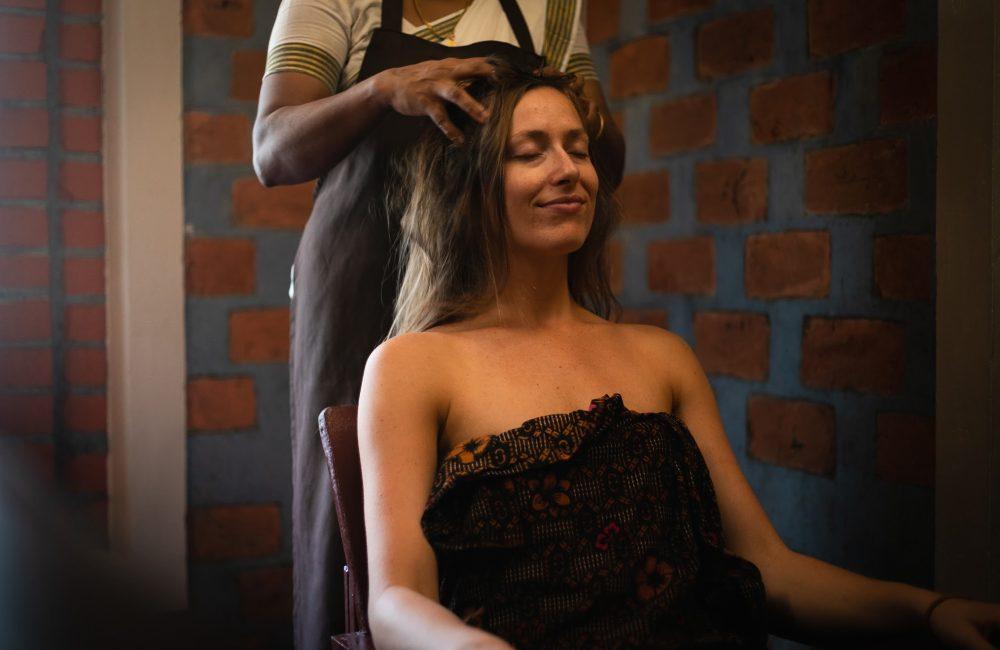 Woman receiving Ayurvedic head massage therapy at a Kerala Ayurvedic resort for relaxation and stress relief