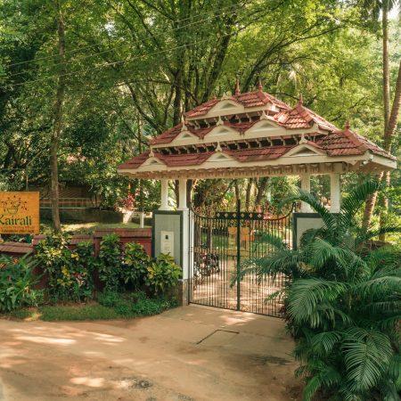 Entrance gate of Kairali Ayurvedic Healing Village surrounded by lush greenery in Kerala