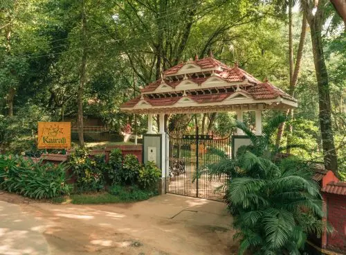 Entrance gate of Kairali Ayurvedic Healing Village surrounded by lush greenery in Kerala