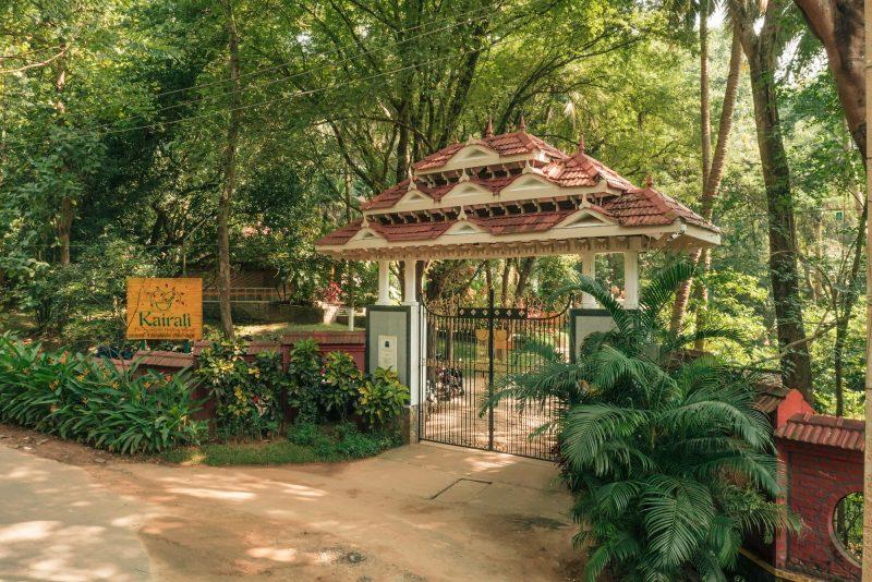 Entrance gate of Kairali Ayurvedic Healing Village surrounded by lush greenery in Kerala