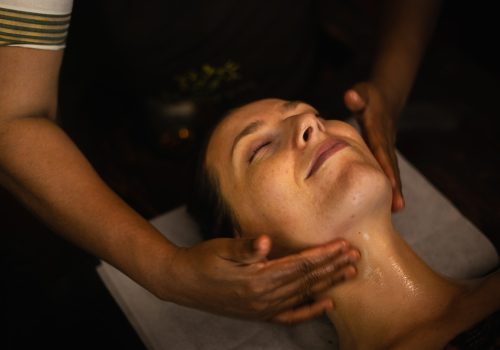Therapist performing facial massage as part of an Ayurvedic monsoon skincare routine