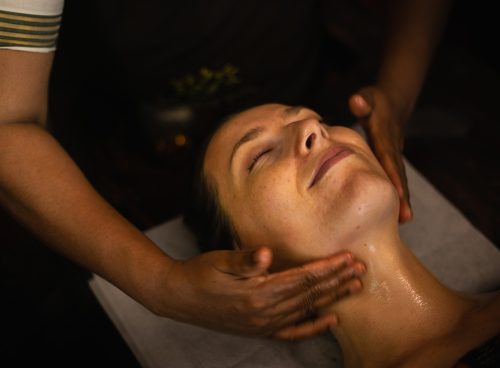 Therapist performing facial massage as part of an Ayurvedic monsoon skincare routine