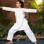 International Yoga Day 2026 yoga session featuring a participant practising a standing yoga posture in a wellness setting