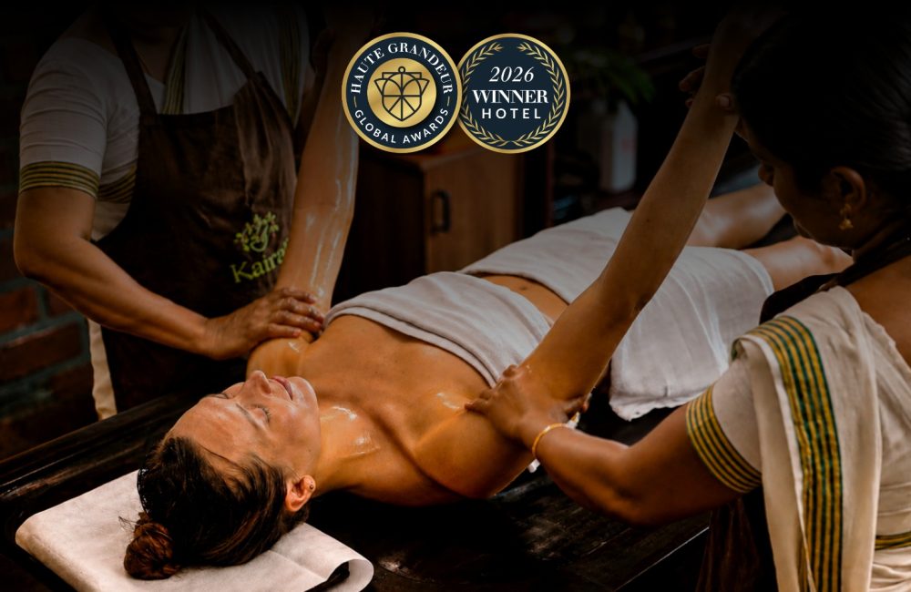 Kairali Ayurvedic therapists performing a traditional Ayurvedic oil therapy at Kairali – The Ayurvedic Healing Village, recognised at the 2026 Haute Grandeur Global Excellence Awards.