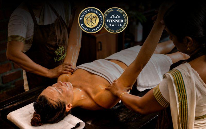 Kairali Ayurvedic therapists performing a traditional Ayurvedic oil therapy at Kairali – The Ayurvedic Healing Village, recognised at the 2026 Haute Grandeur Global Excellence Awards.
