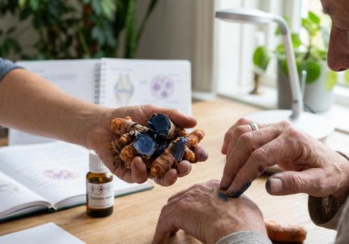 Blue turmeric for joint health shown during a discussion about joint care, with fresh Curcuma caesia rhizomes beside an older adult.
