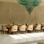 Elegant dining area at Villa Raag, a yoga retreat in Goa, with sculptural wall art and contemporary interiors.