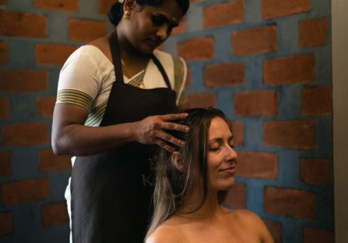 Woman receiving a relaxing Ayurvedic head massage, highlighting preventive mental wellbeing and self-care on World Mental Health Day 2026.