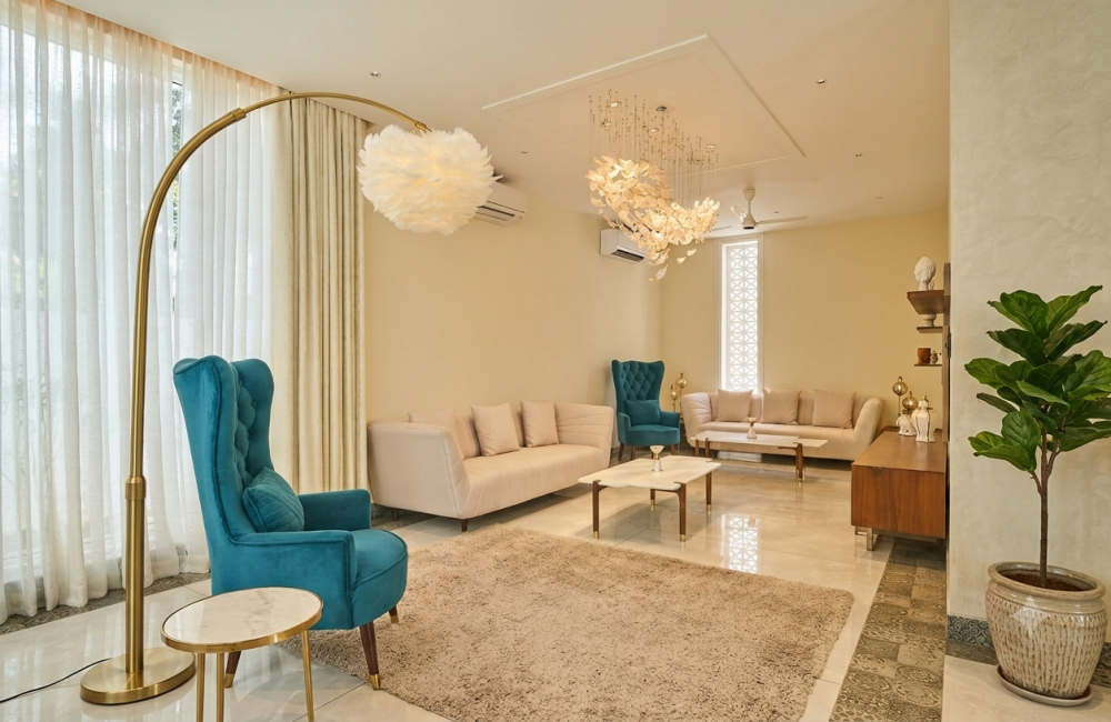 Elegant lounge interior with teal armchairs, cream sofas, modern lighting and comfortable seating for a workation in Agonda.
