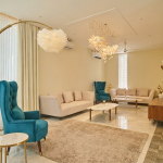 Elegant lounge interior with teal armchairs, cream sofas, modern lighting and comfortable seating for a workation in Agonda.