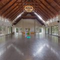 Yoga to lower cortisol: A guided yoga session at Kairali Ayurvedic Healing Village in Palakkad, Kerala, inside a spacious, naturally lit yoga hall.