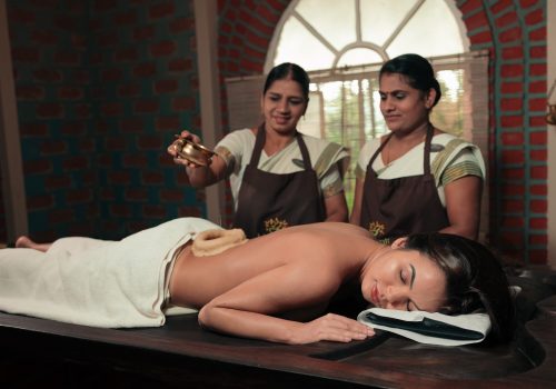 Ayurvedic Abhyanga oil massage being performed by two therapists at Kairali’s Ayurveda centre in Kerala.